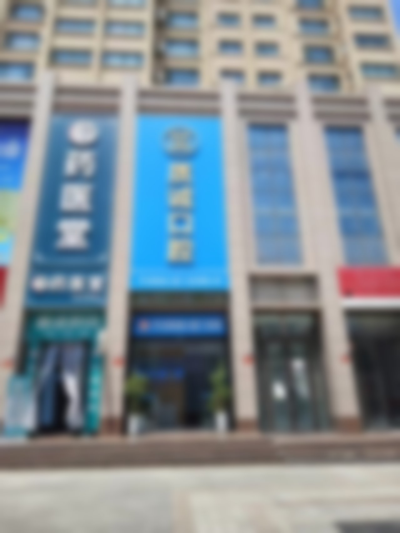 口腔门诊,门头外观,药医堂 这是一张医院外景实拍图,展示了位于一栋米黄色瓷砖建筑